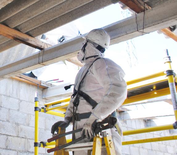 Asbestos removal expert in protective gear inspecting a site